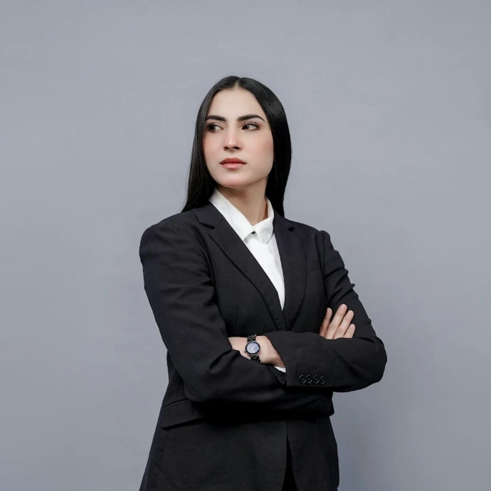 a woman in a business suit with her arms crossed